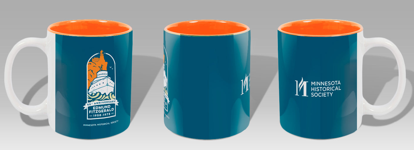 The 50th Anniversary Edmund Fitzgerald Commemorative Mug—blue with an orange interior—is displayed from three angles, showing the 50th anniversary logo and Minnesota Historical Society logo: a fitting tribute to Lake Superior.