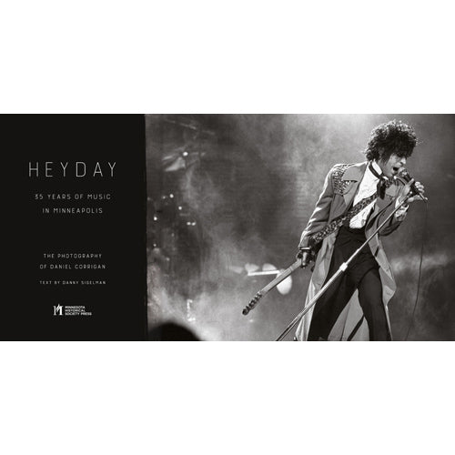 Black-and-white photo of a musician in an elaborate outfit singing and playing guitar on stage, smoky lights evoking First Avenue’s vibe. From "Heyday: 35 Years of Minneapolis Music Photography" by Daniel Corrigan, text by Danny Sigelman.