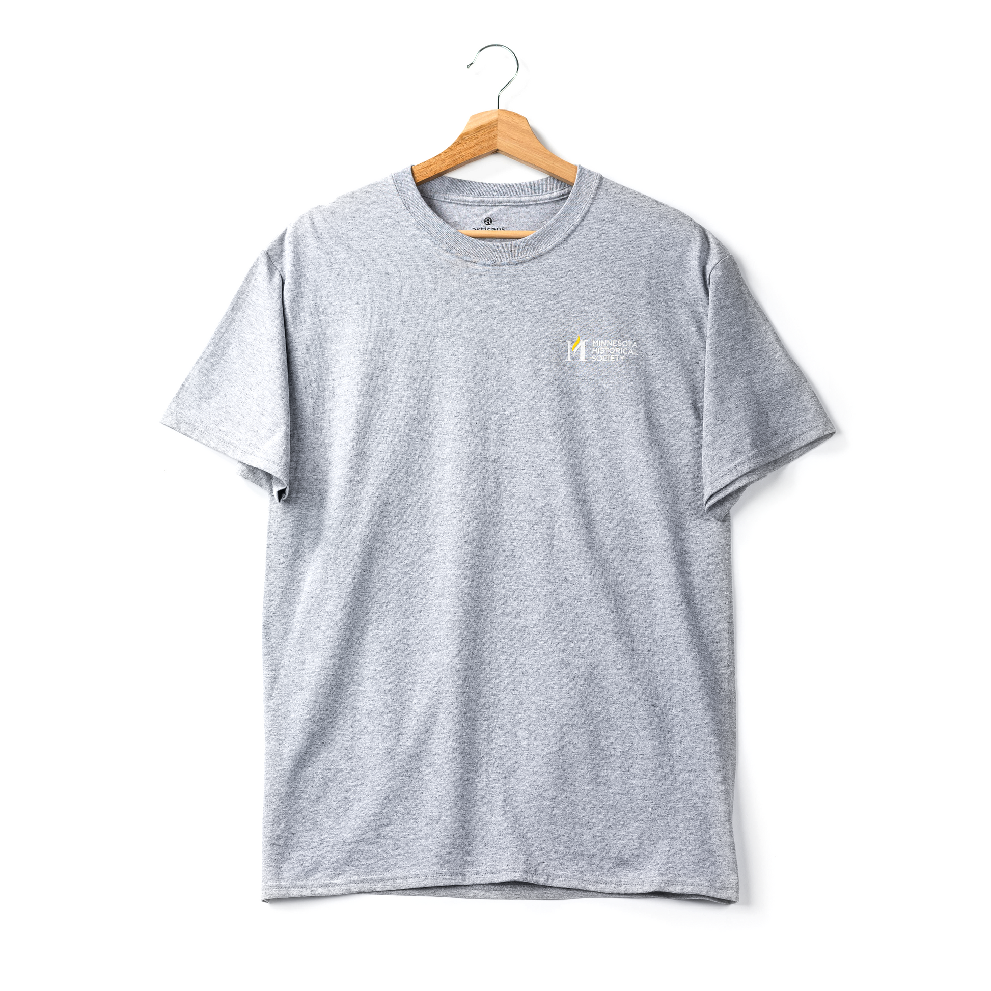 The Minnesota Historical Society Icon T-Shirt hangs on a wooden hanger against a white background, featuring a classic logo and text on the left chest.